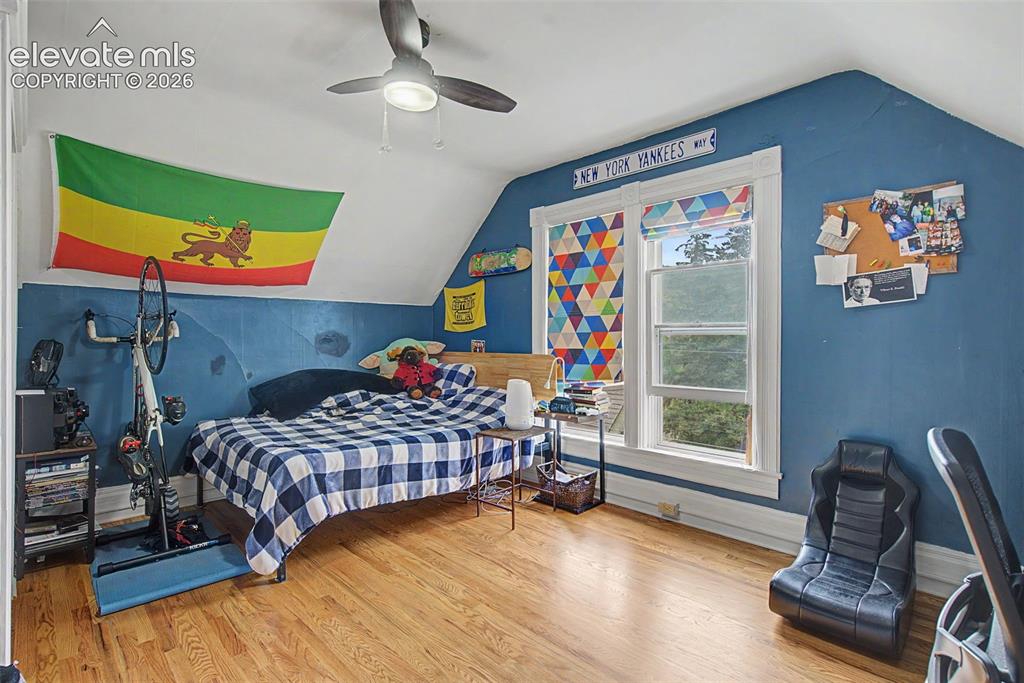 Image 34 of 50: Upper bedroom featuring wood flooring and ceiling fan