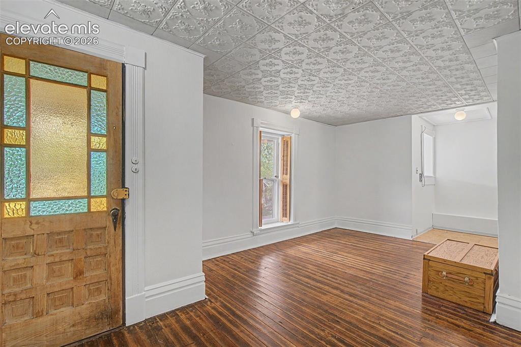 Image 37 of 50: Secondary suite entrance featuring hardwood flooring and open concept to di