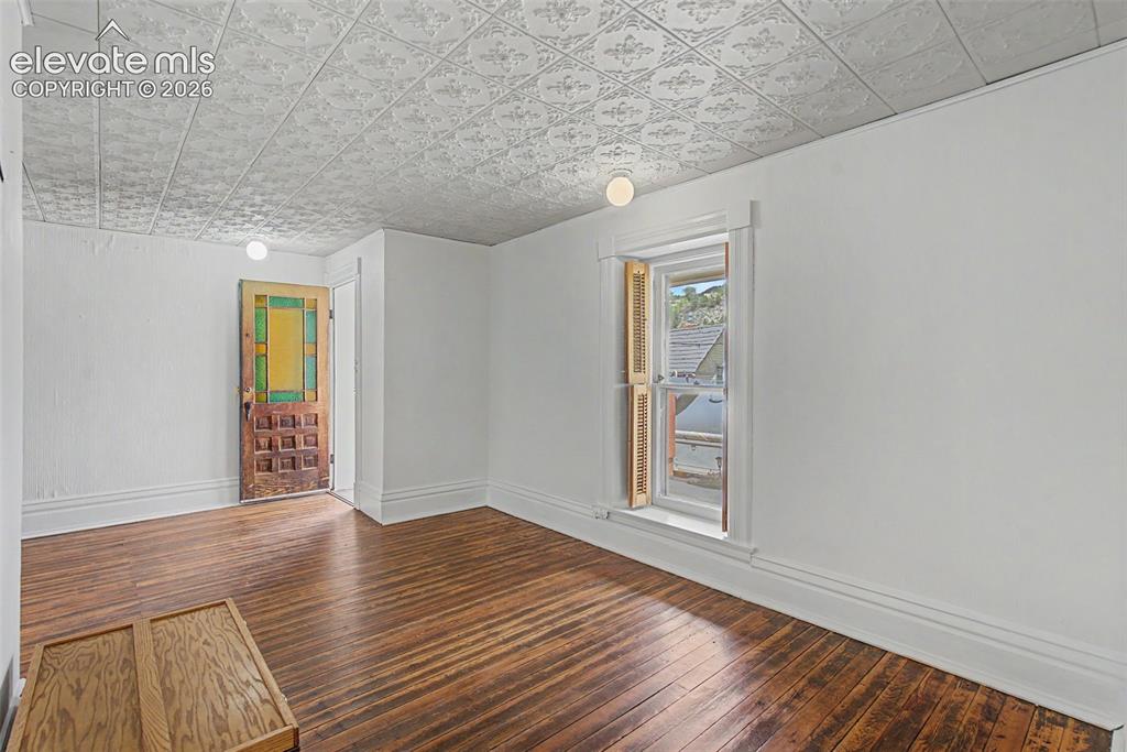 Image 38 of 50: Secondary suite entrance featuring hardwood flooring and Victorian style ce