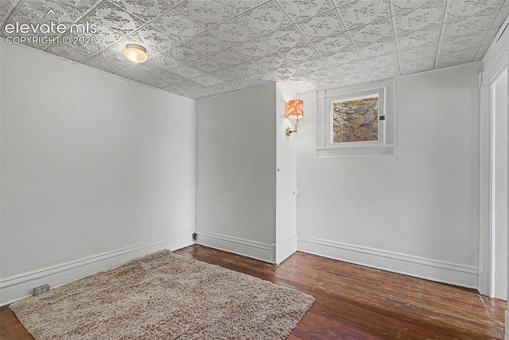 Image 40 of 50: Secondary suite bedroom featuring hardwood flooring