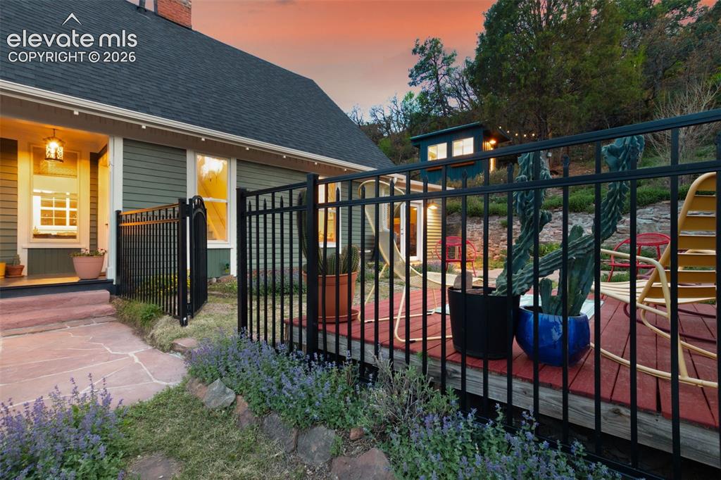 Image 6 of 50: Rear exterior featuring a wood deck, double doors from the primary bedroom,