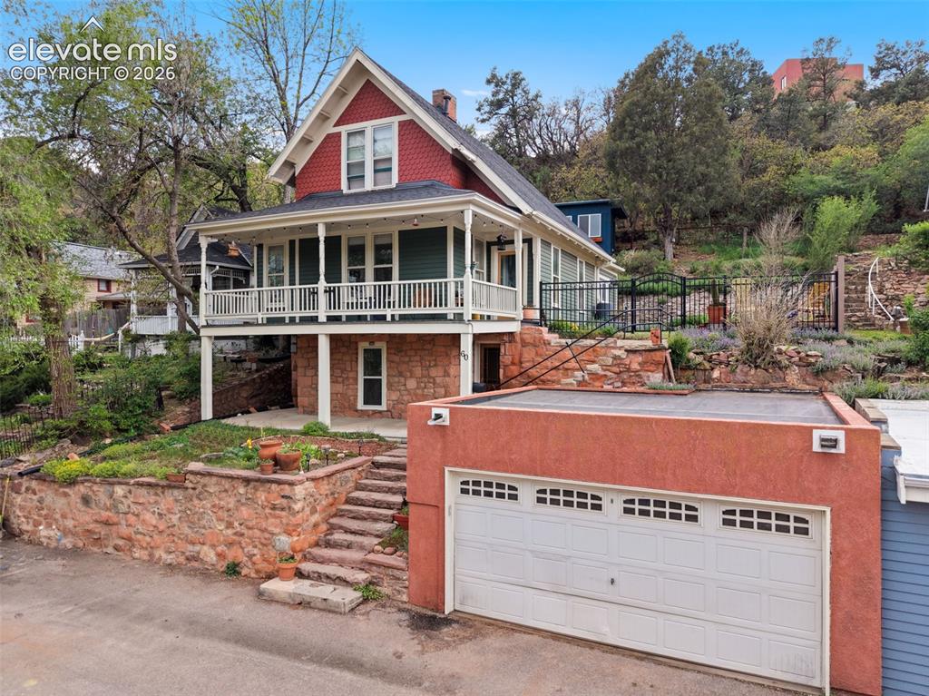 Image 7 of 50: Exterior view featuring a flagstone pathway, a wooden deck, and backyard st