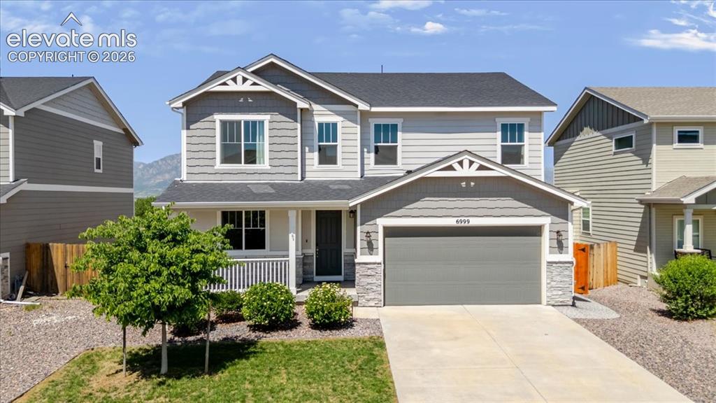 Image 1 of 50: Two-story residence featuring a gray exterior with shingle siding accents a