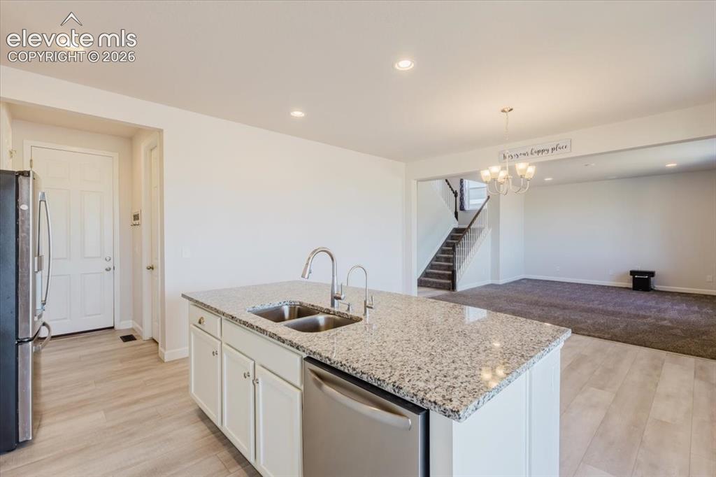 Image 10 of 50: Kitchen island with a double basin stainless steel sink, granite-style coun