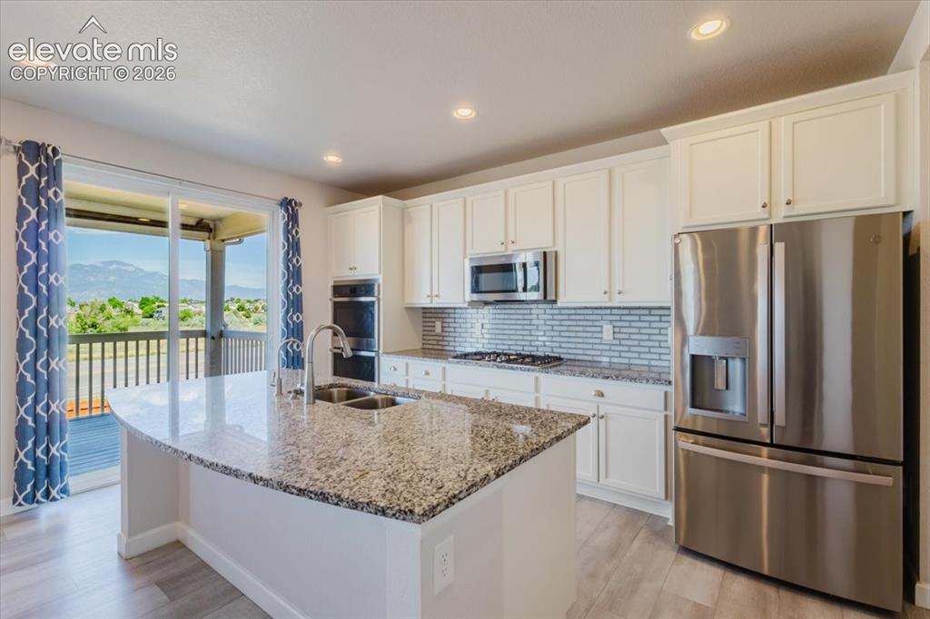 Image 11 of 50: Kitchen featuring a large island with an undermount double sink, granite co