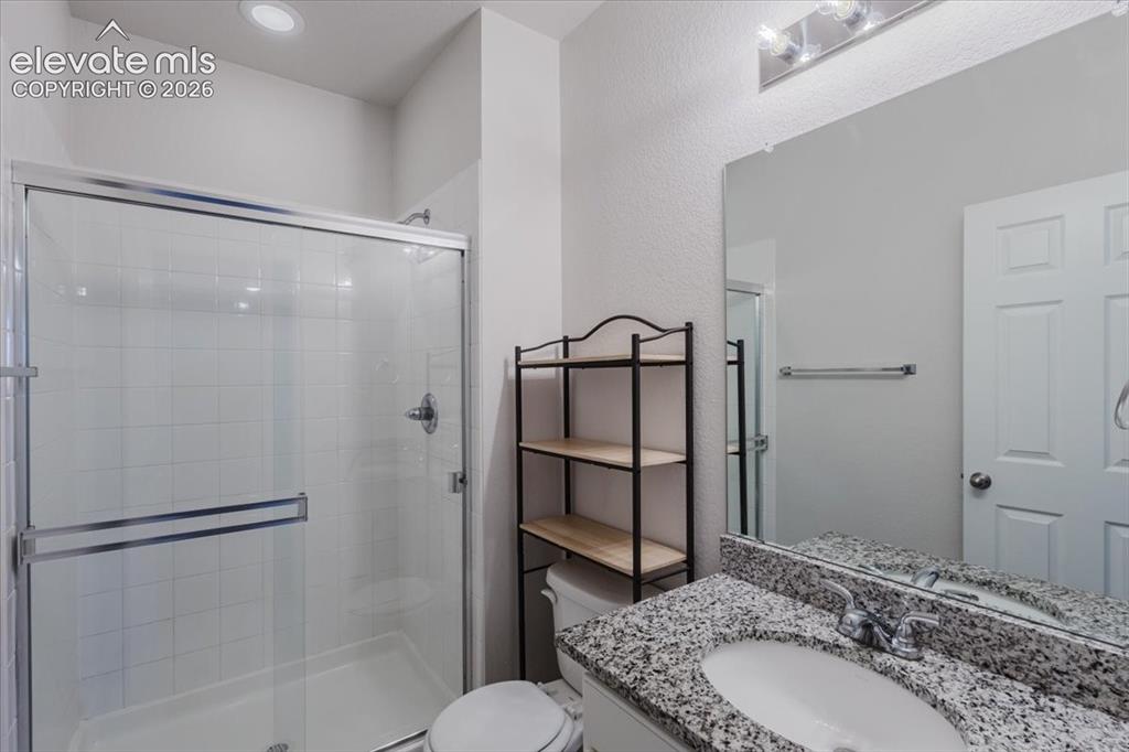 Image 14 of 50: Bathroom featuring a granite-finish vanity with an undermount sink, a large