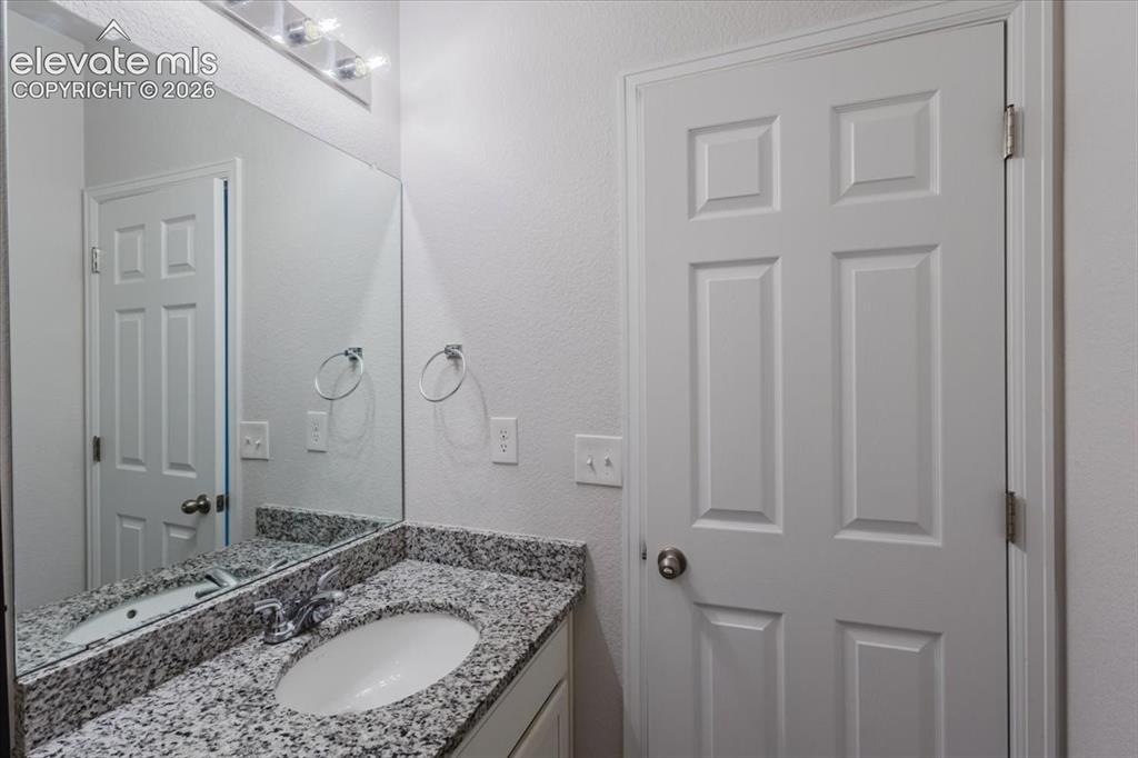 Image 15 of 50: Bathroom vanity featuring an integrated oval sink, stone-finish countertop,