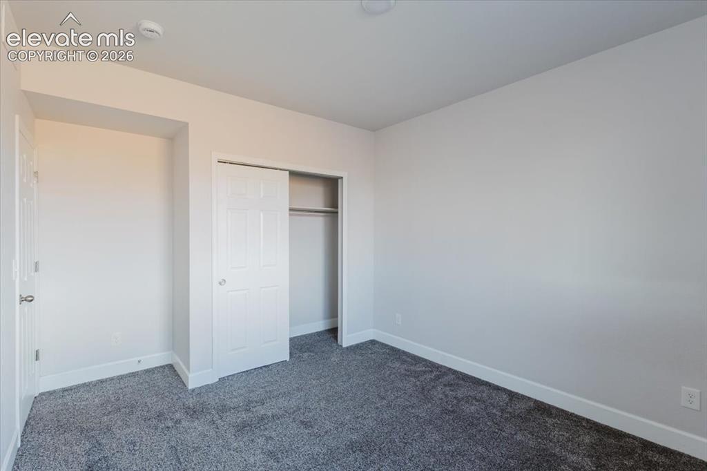 Image 19 of 50: Neutral tone wall paint, grey pile carpeting, and a bi-fold closet door