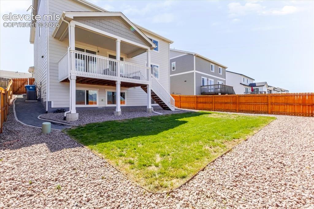Image 26 of 50: Rear exterior with a covered upper deck, lower level patio door access, a g