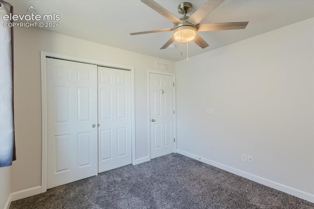 Image 32 of 50: Room featuring neutral wall paint, gray textured carpet, and white baseboar