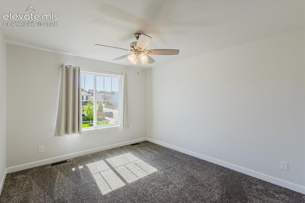 Image 38 of 50: Carpeted interior space featuring a window with a light-colored curtain, a 