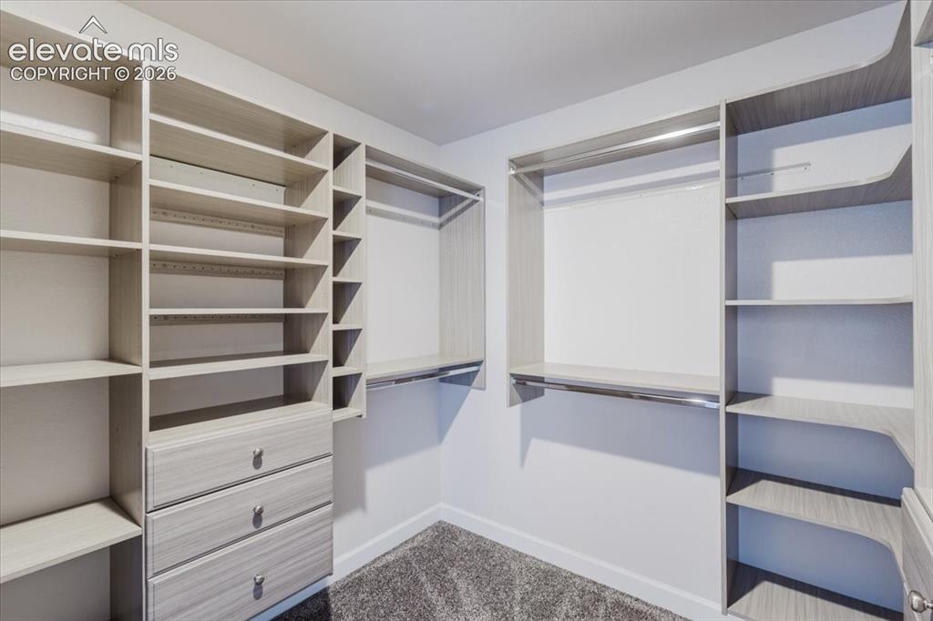 Image 44 of 50: Custom closet organization system featuring modular shelving, hanging rods,