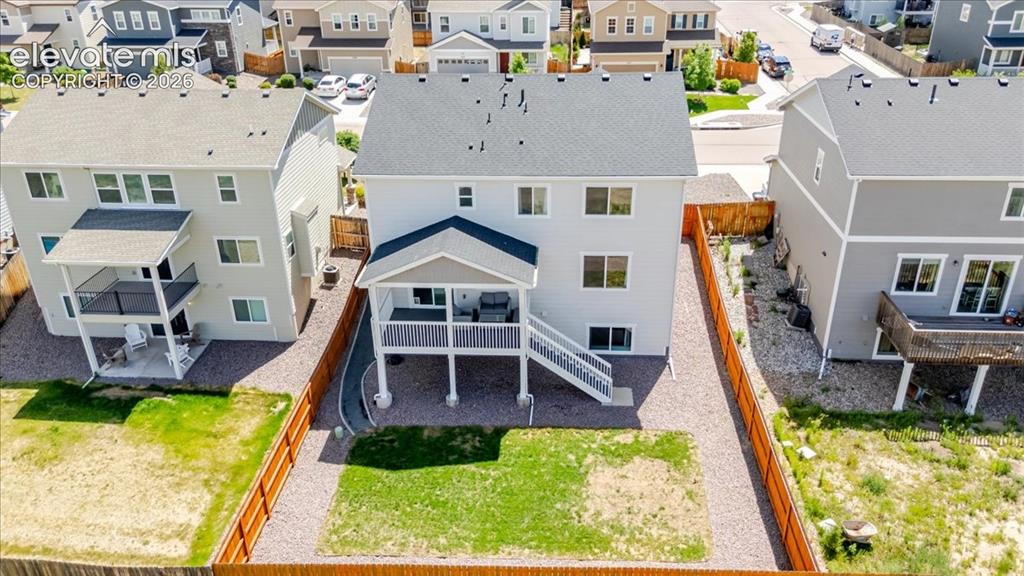 Image 5 of 50: Rear exterior featuring light gray siding, a covered deck, a lower-level pa