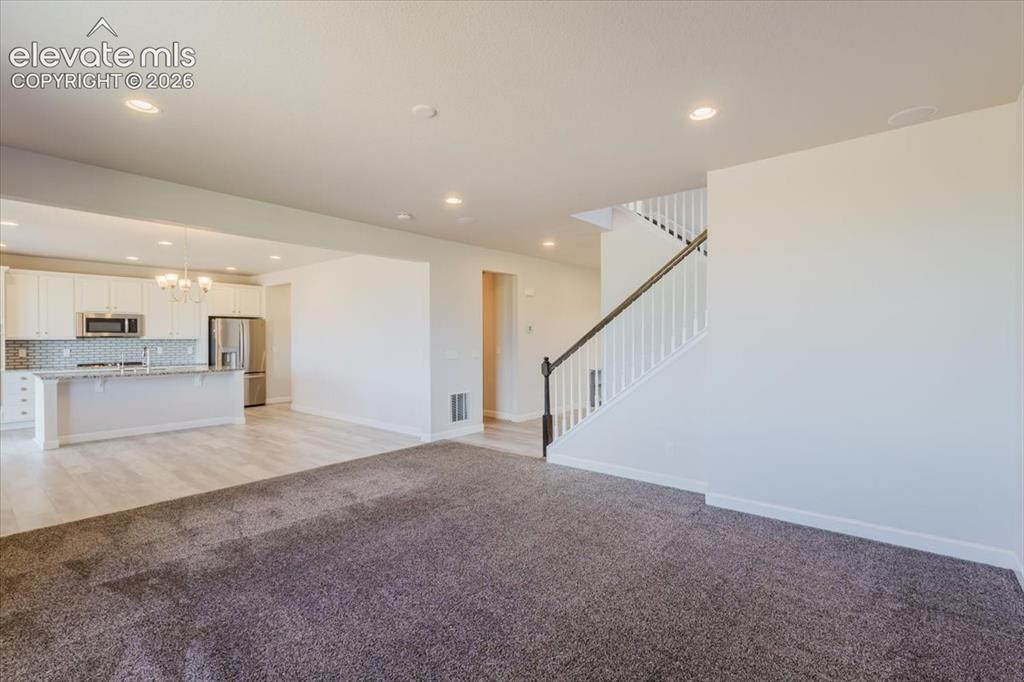 Image 6 of 50: Open-concept living area featuring a neutral color palette, recessed lighti