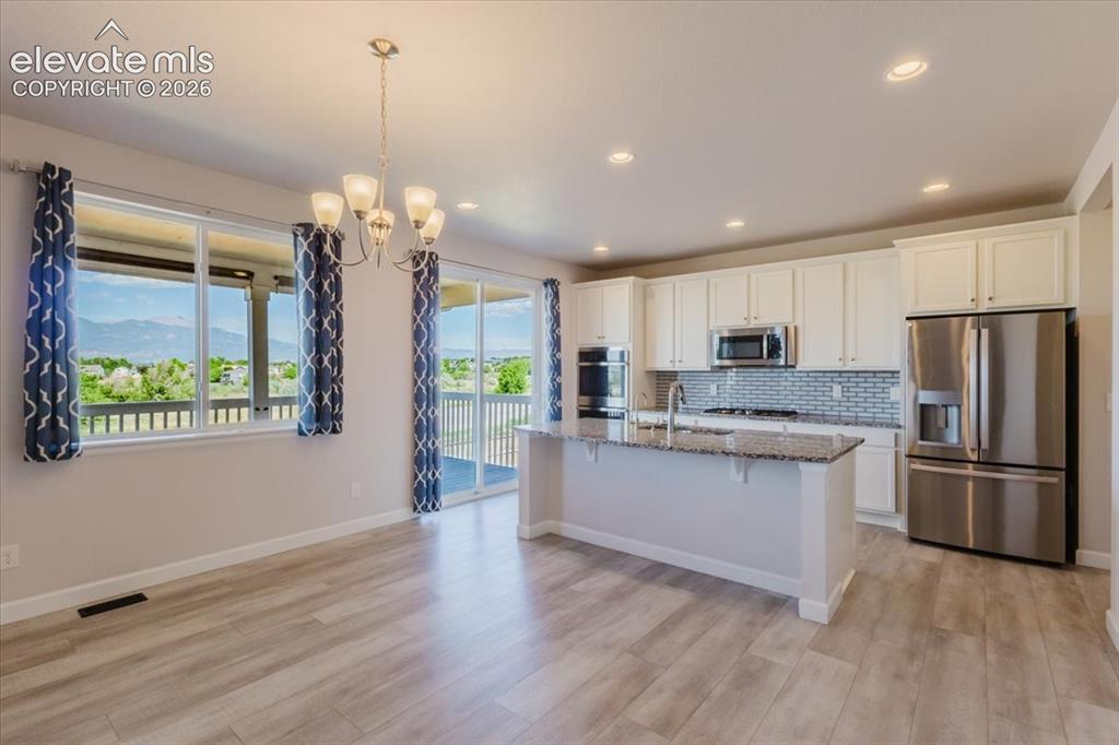 Image 8 of 50: Open-concept living space featuring wood-finish flooring, a kitchen island 