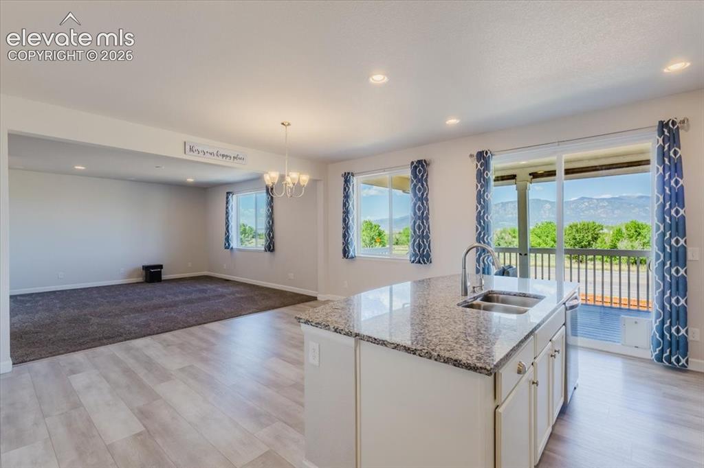 Image 9 of 50: Kitchen island with granite countertop and double stainless steel sink