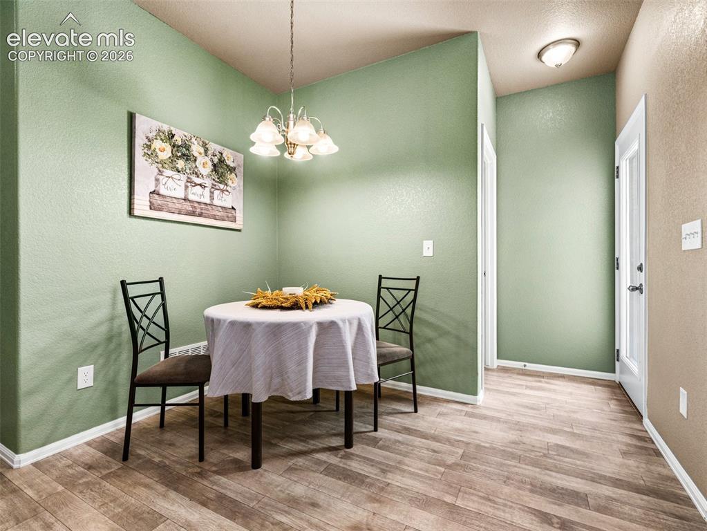 Image 10 of 24: Wood-finish flooring, recessed lighting, chandelier, white trim, and a whit