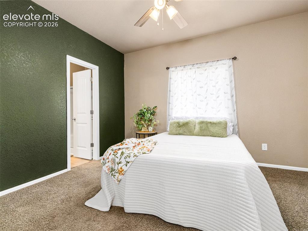 Image 11 of 24: Carpeted flooring, ceiling fan with integrated lighting, window with curtai