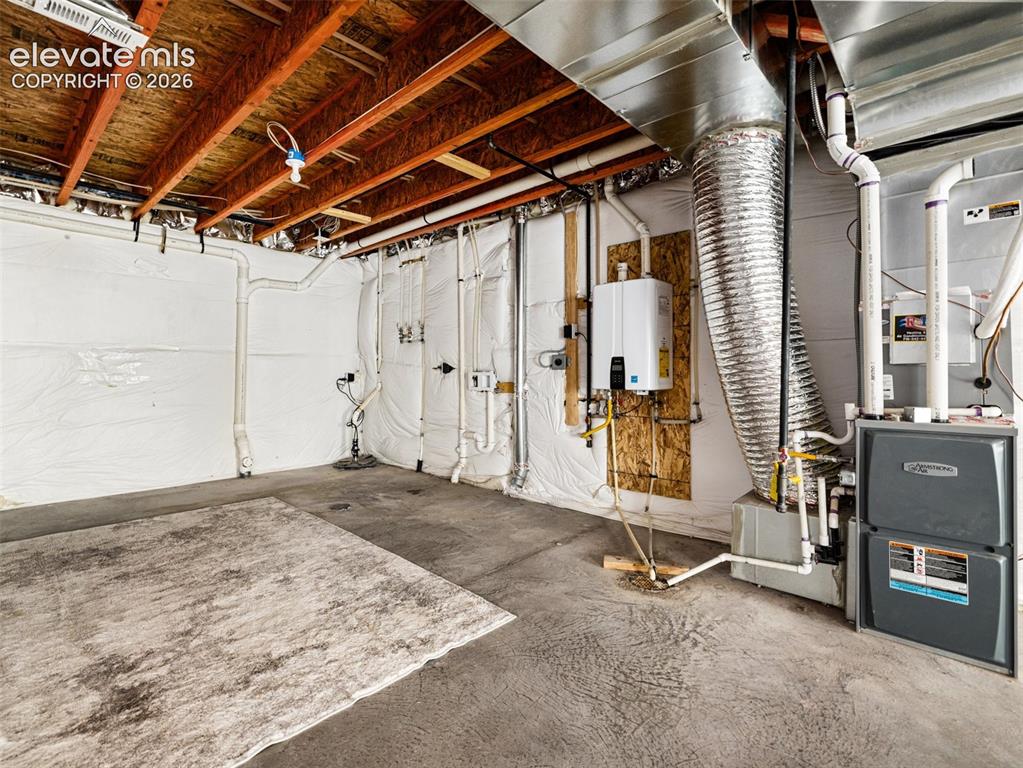 Image 20 of 24: Exposed ceiling joists with subflooring above, concrete flooring, wall-moun