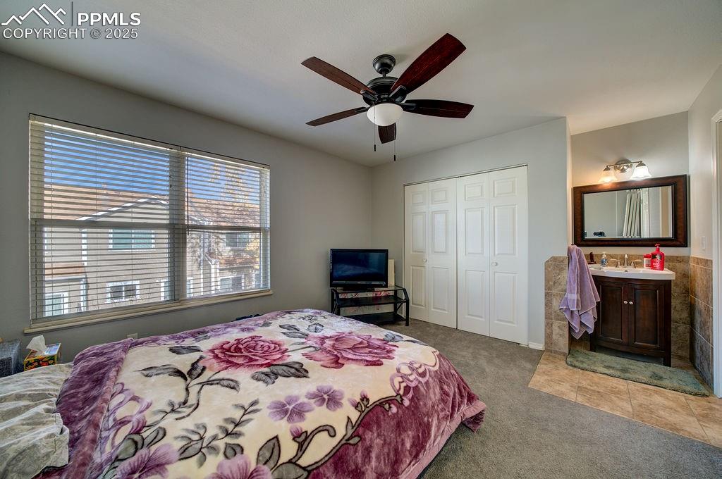 Image 30 of 37: Upper level Bedroom #2 has an adjoining Bathroom with vanity, framed mirror