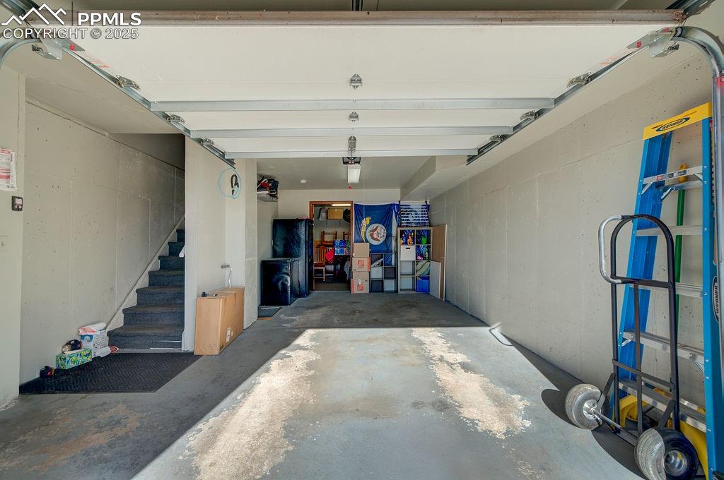 Image 32 of 37: Oversized 1 car garage with door opener and storage.