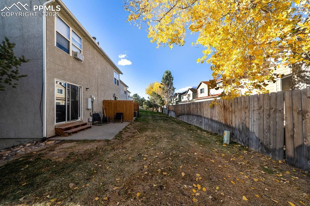 Image 35 of 37: Rear view of building with private patios and grass area.