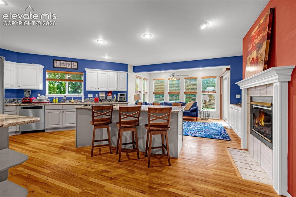 Image 10 of 50: Kitchen with light wood-finish flooring and white cabinetry