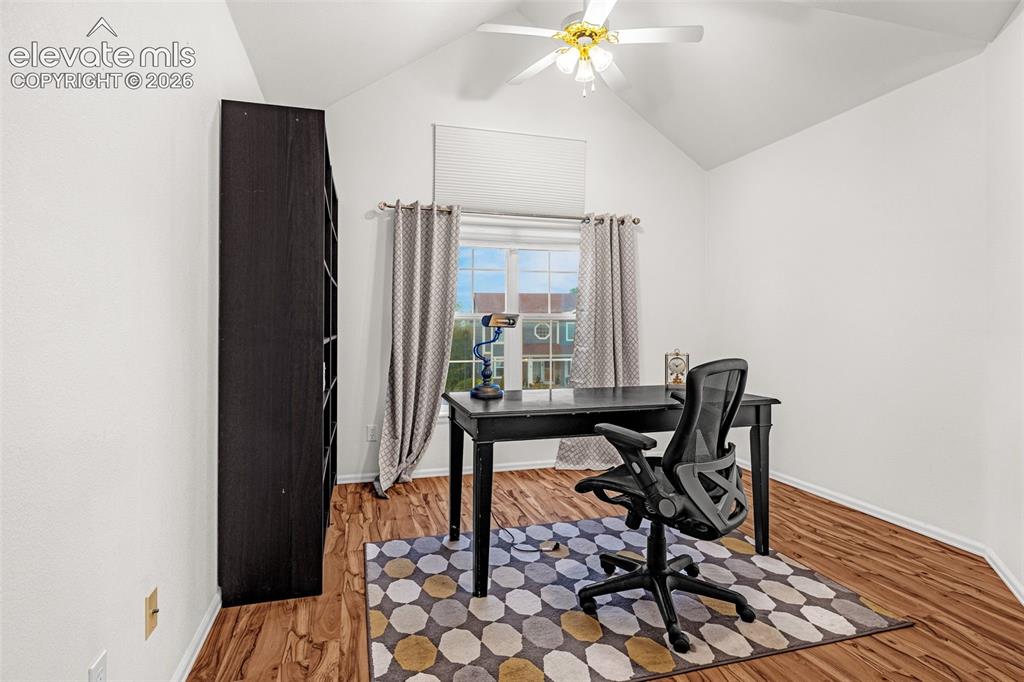 Image 23 of 50: Vaulted ceiling with a ceiling fan and light fixture, wood-finish flooring,