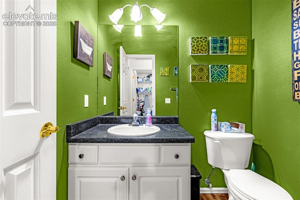 Image 24 of 50: White vanity with a black countertop and an integrated sink