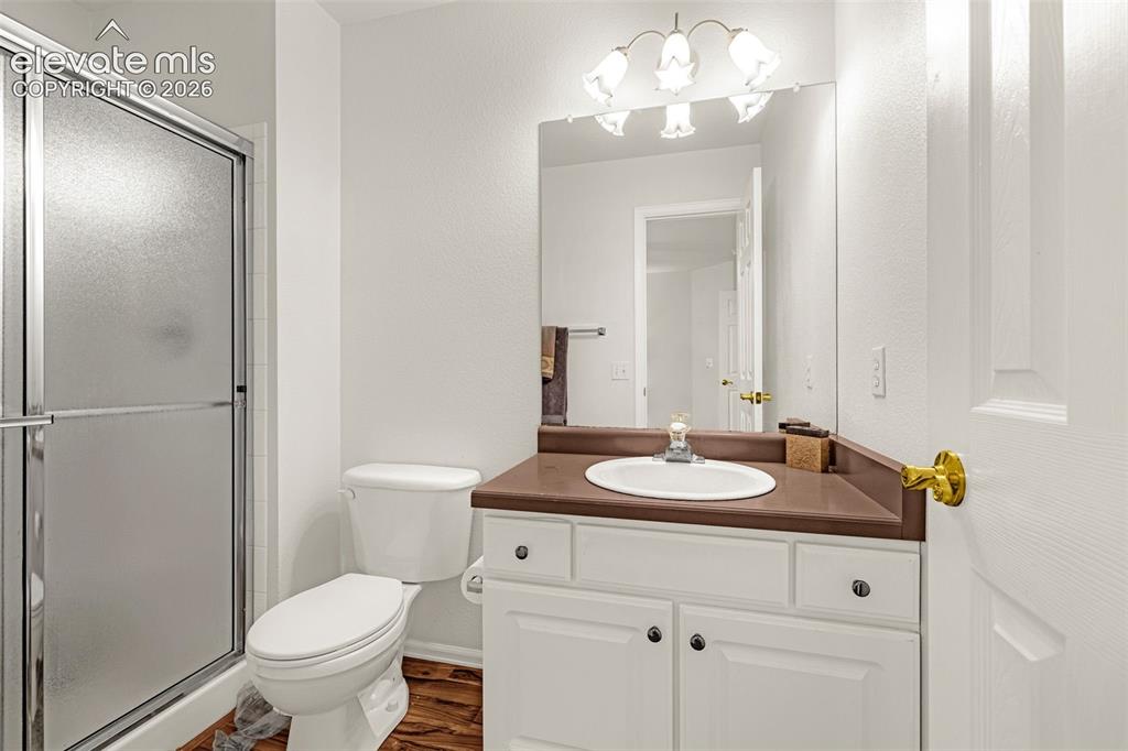 Image 26 of 50: White vanity with dark hardware, brown countertop, and an oval sink