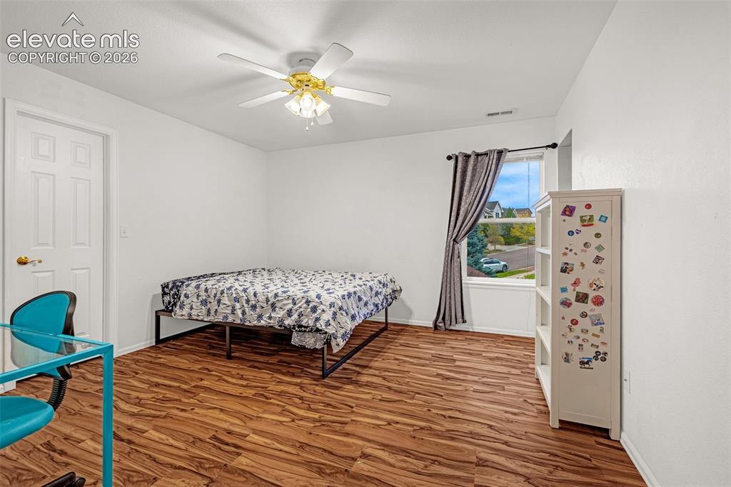 Image 27 of 50: Room featuring wood-finish flooring, a ceiling fan with integrated lighting