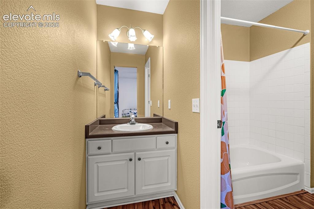 Image 28 of 50: Vanity with an integrated sink, polished chrome faucet, and a large mirror
