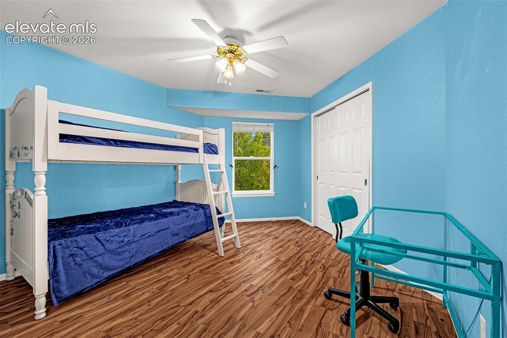 Image 30 of 50: Recessed window, wood-finish flooring, ceiling fan, and white bi-fold close