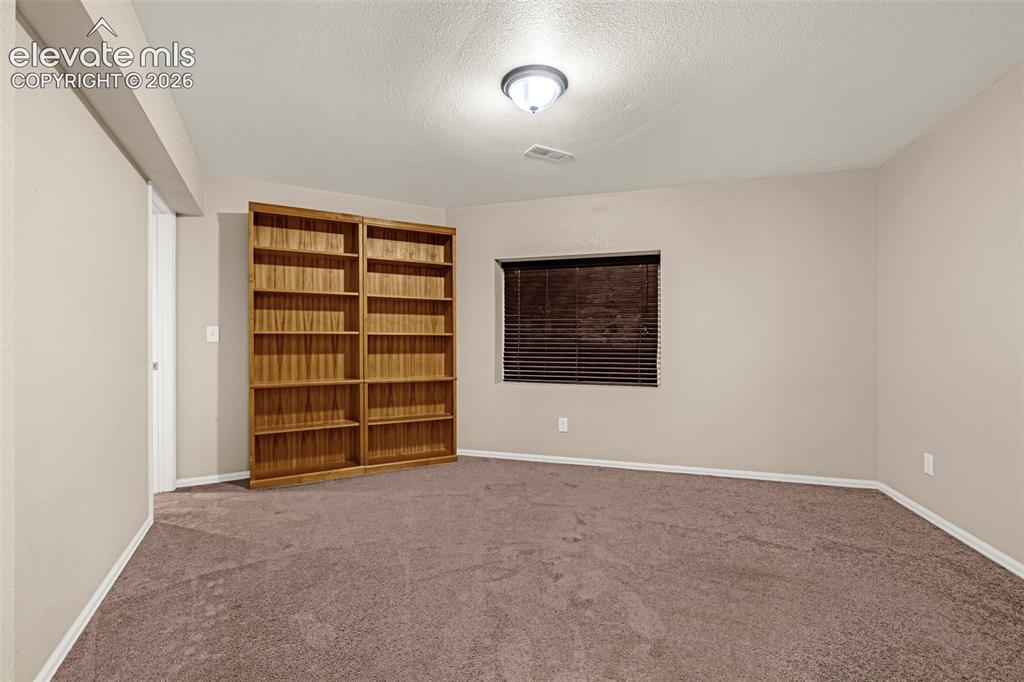 Image 31 of 50: Carpeted flooring, recessed window with blinds, overhead flush mount lighti