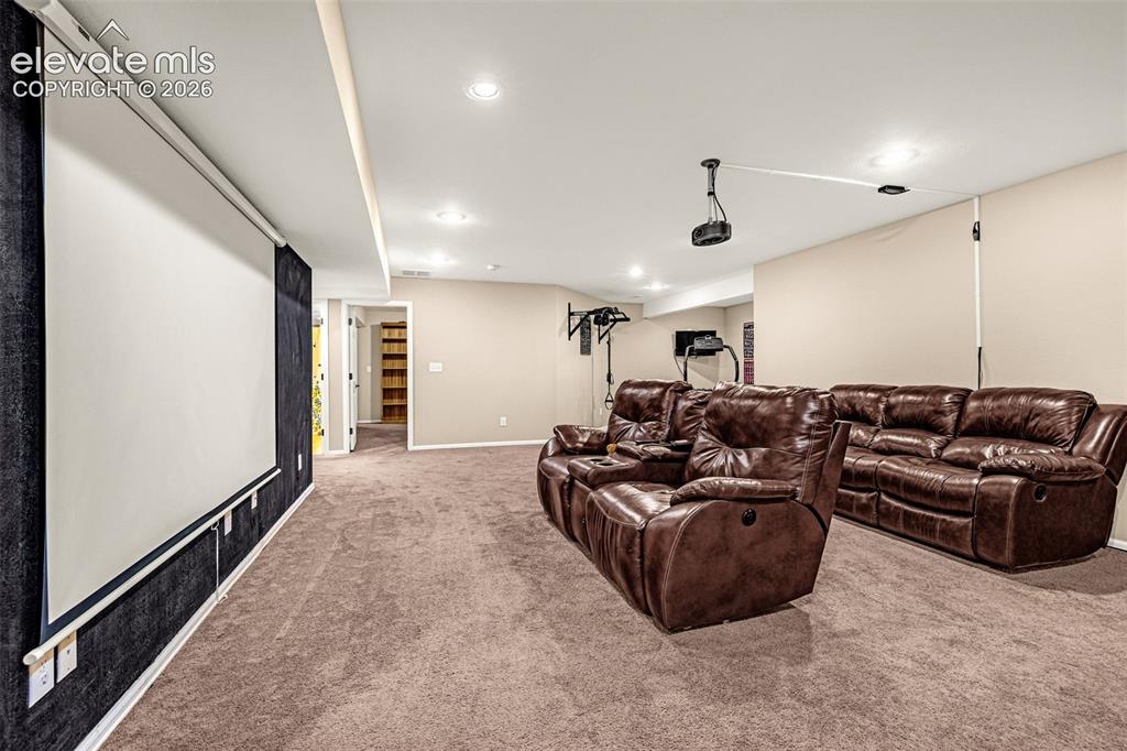 Image 33 of 50: Expansive entertainment room with recessed lighting, integrated projector,