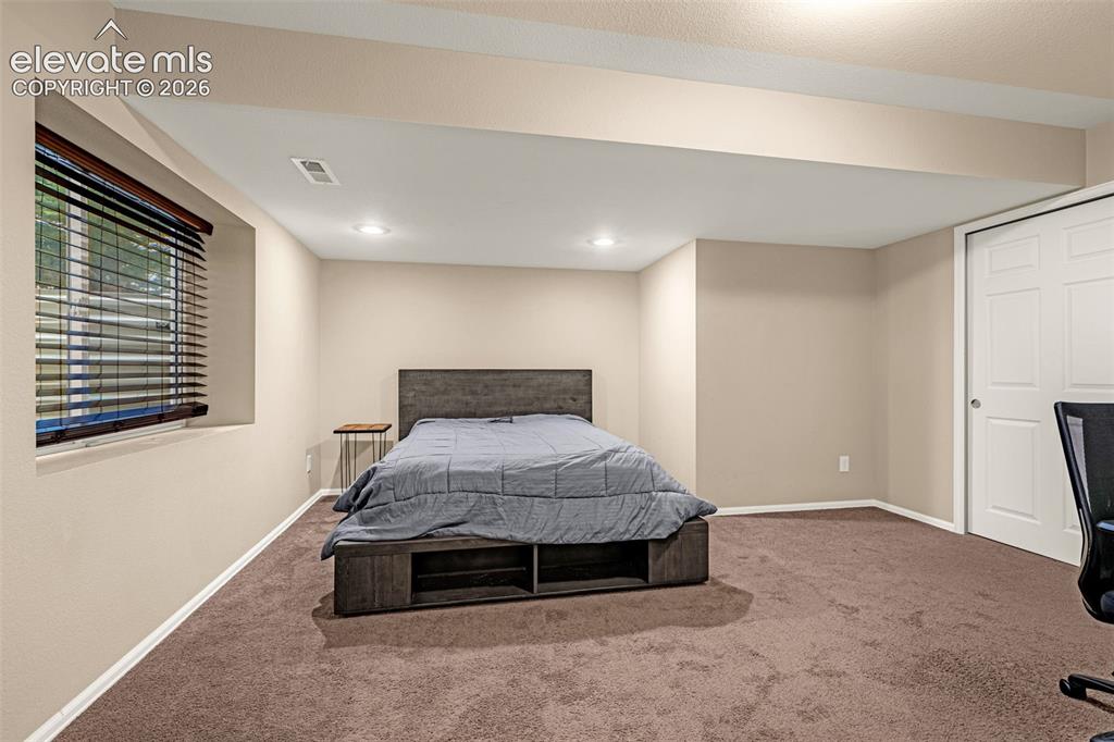 Image 35 of 50: Recessed lighting, neutral wall paint, and brown carpet flooring