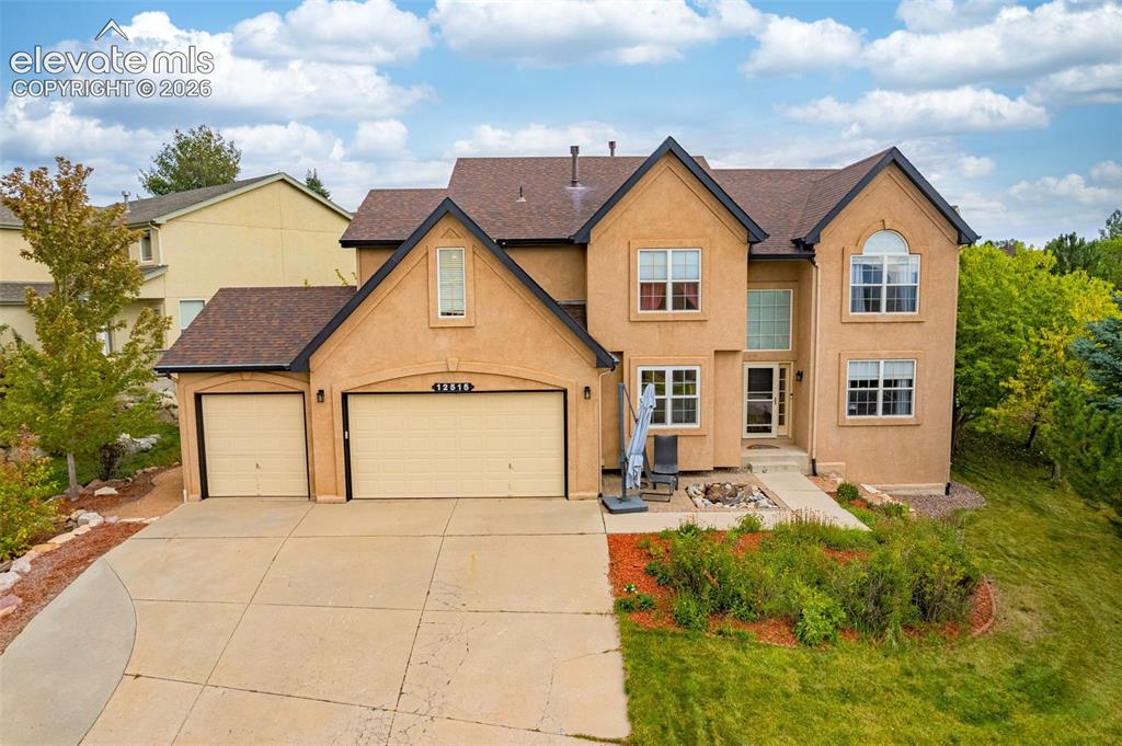 Image 42 of 50: Stucco exterior with a multi-level roofline, prominent gables, an attached 