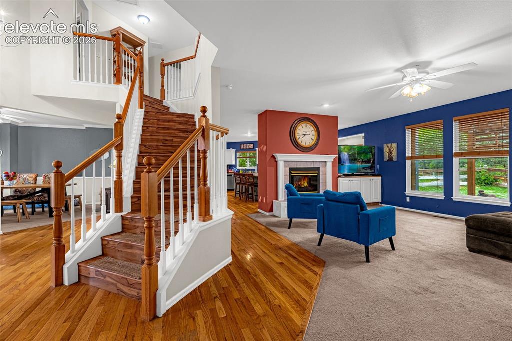 Image 9 of 50: Hardwood flooring, two-story staircase with wood newel posts, built-in fire