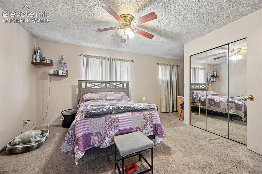 Image 10 of 20: Bedroom featuring textured ceiling, neutral-toned walls, and carpet floorin