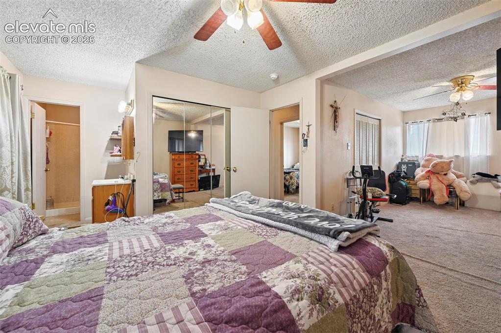 Image 11 of 20: Bedroom featuring a ceiling fan, mirrored closet doors, an alcove with an o