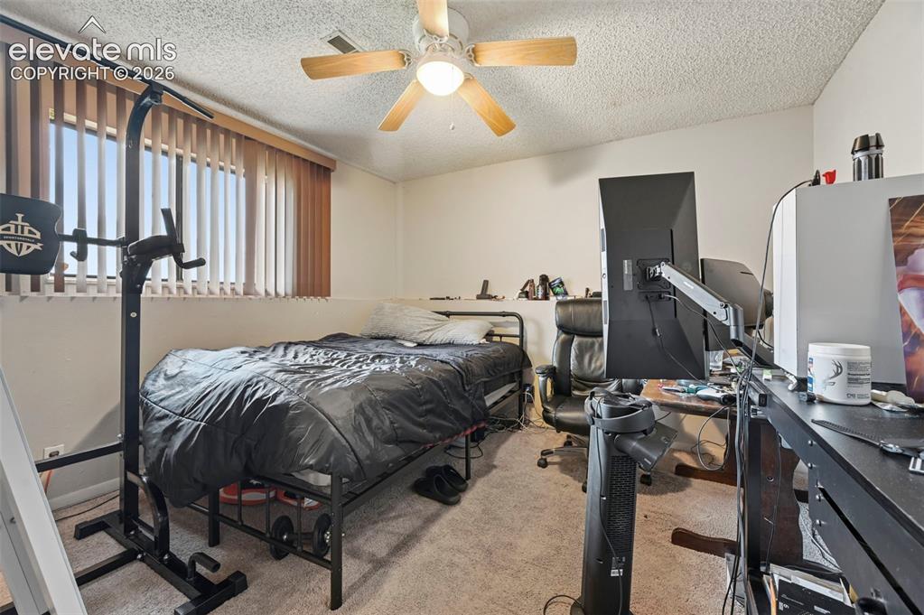 Image 13 of 20: Bedroom featuring a ceiling fan with integrated lighting, carpeted flooring