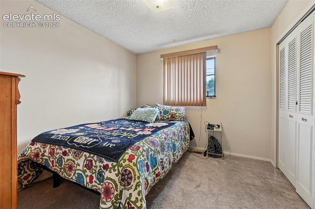 Image 14 of 20: Wall-to-wall carpeted bedroom featuring a louvered bi-fold closet and a win