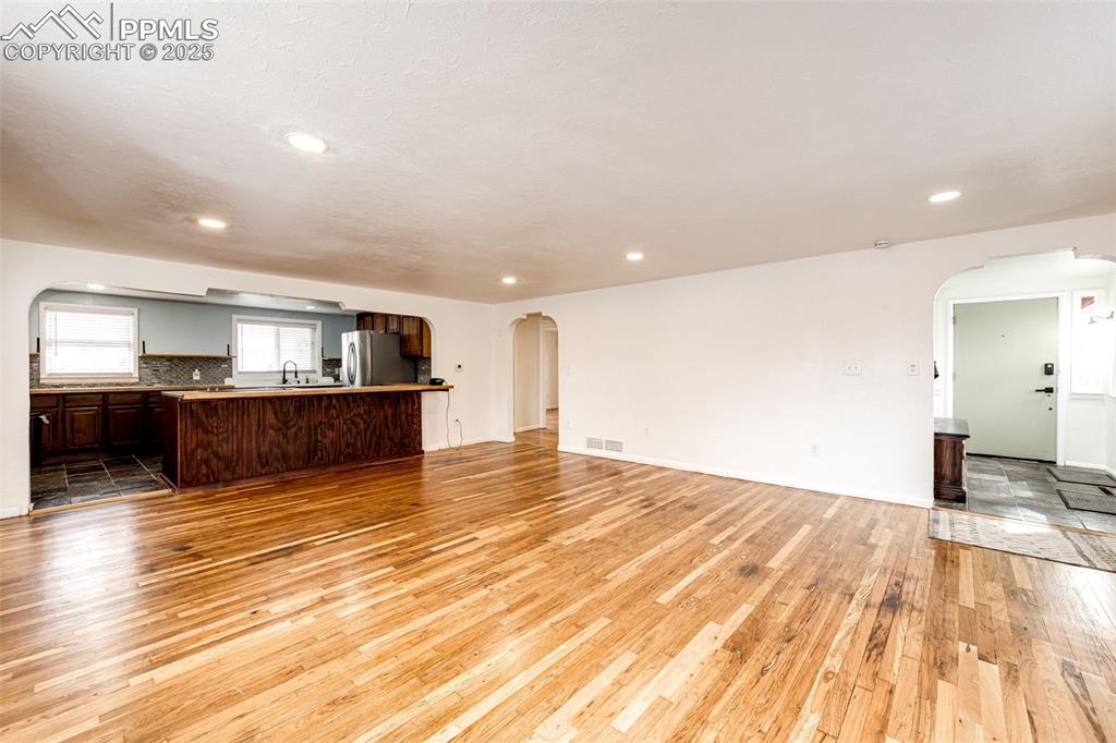 Image 8 of 34: Open to the kitchen living room with refinished floors, arched walkways, an