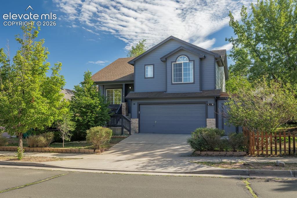 Caption: Two-story residence featuring a two-car garage, stone accents, and an arched window