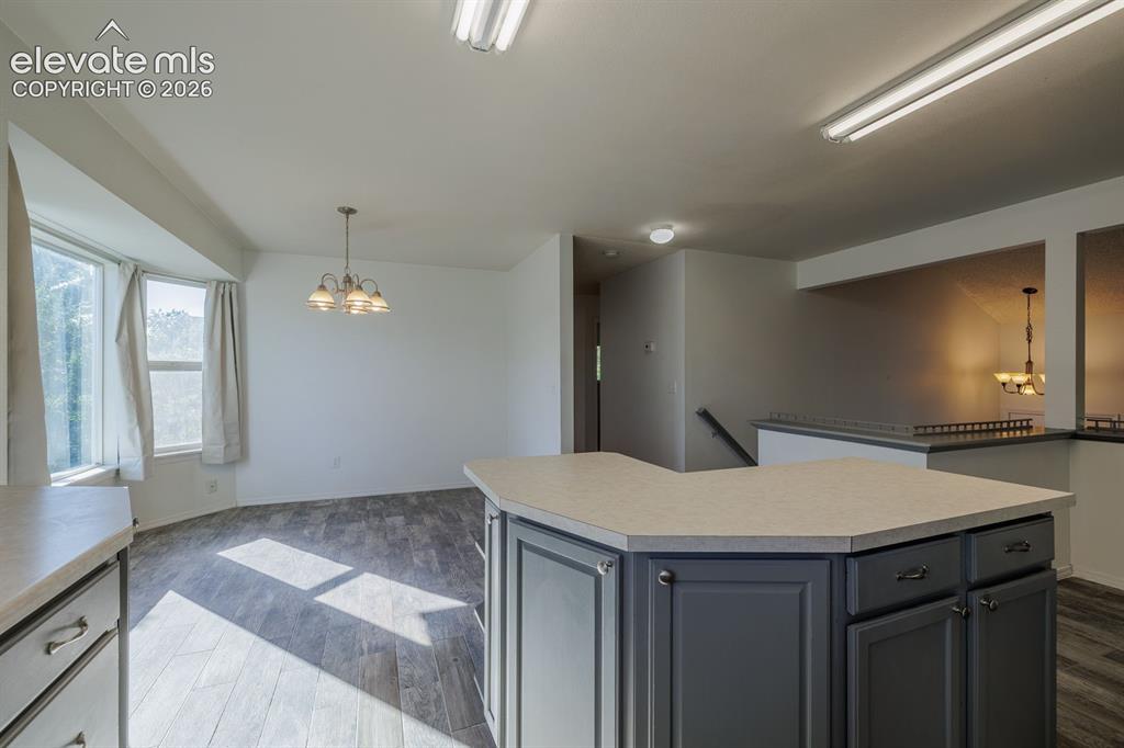Image 14 of 36: Kitchen island with gray cabinetry and light-toned countertops
