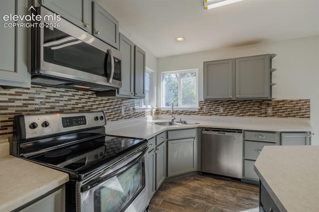 Image 15 of 36: Contemporary kitchen with stainless steel appliances, light gray cabinetry,