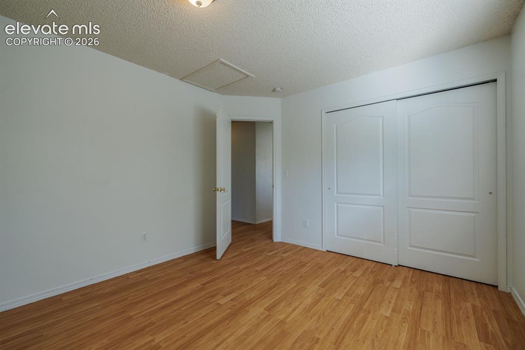 Image 19 of 36: Wood-finish flooring, white walls, and a white ceiling with a flush-mount l