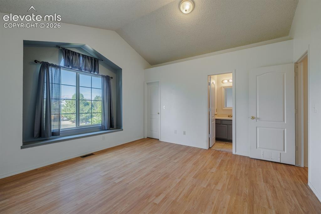 Image 24 of 36: Vaulted ceiling, wood-finish flooring, large window with deep sill, built-i