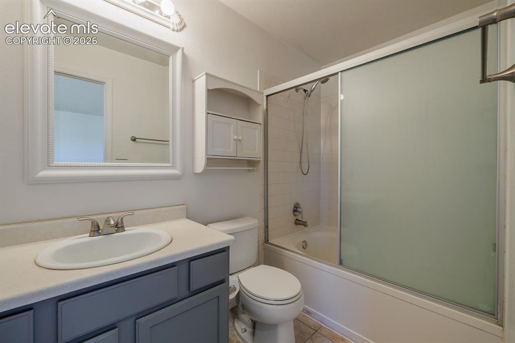 Image 26 of 36: Vanity with integrated sink, brushed nickel faucet, framed mirror, and buil