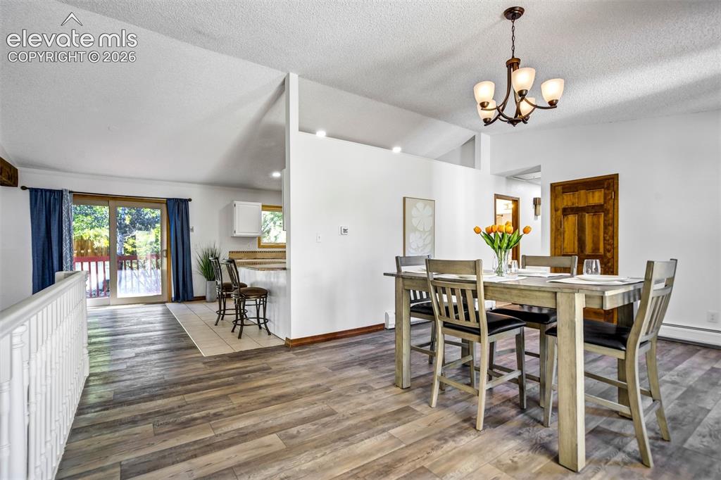 Image 10 of 45: Dining area featuring wood-finish flooring and a contemporary chandelier